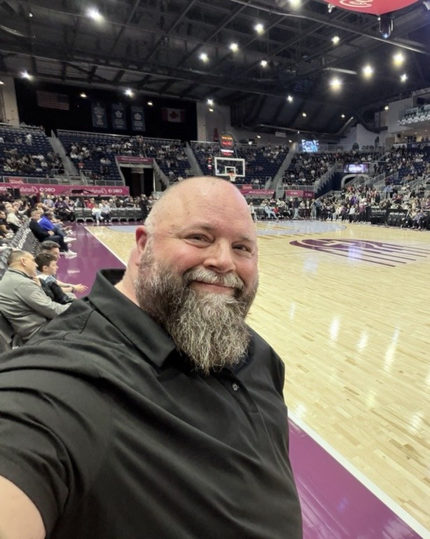 Nolin LeChasseur courtside at a Toronto Tempo game, in a black shirt